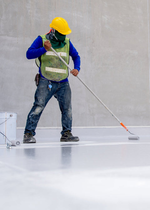 Worker using a floor polisher on a concrete floor.